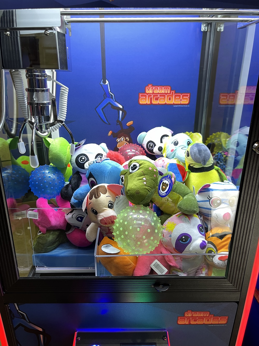 Narrow Claw Machine filled with stuffed animals